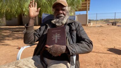 Indigenous Australian man holds bible