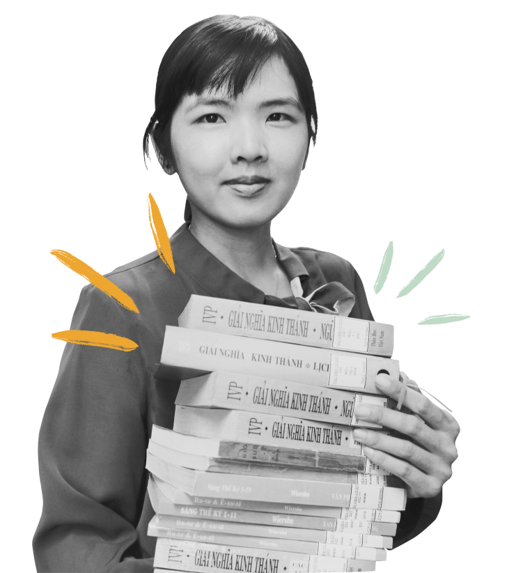 A friendly Vietnamese girl smiling while holding a pile of Christian books and looking at the camera.